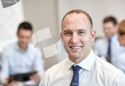 Image of group of smiling businesspeople meeting in office