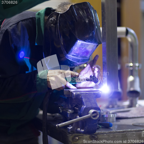 Image of Industrial worker welding in metal factory.