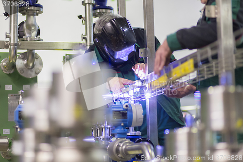 Image of Industrial worker welding in metal factory.