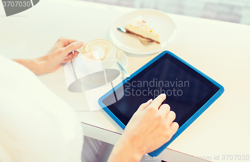 Image of close up of woman with tablet pc drinking coffee