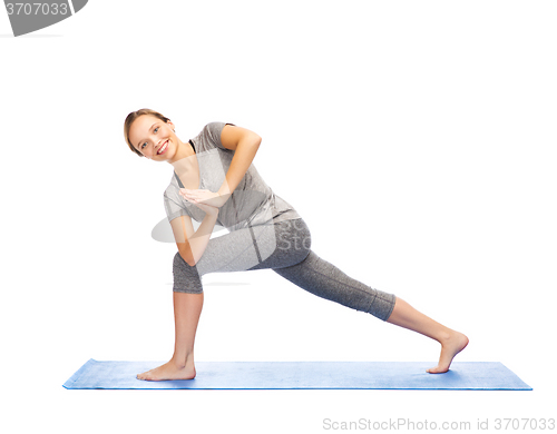 Image of woman making yoga low angle lunge pose on mat