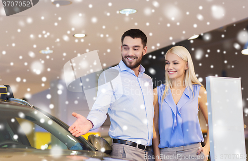Image of happy couple buying car in auto show or salon