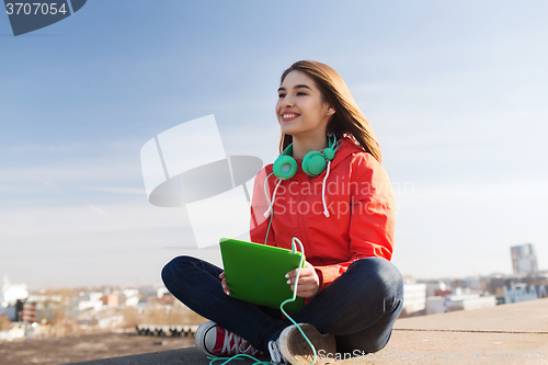 Image of happy young woman with tablet pc and headphones