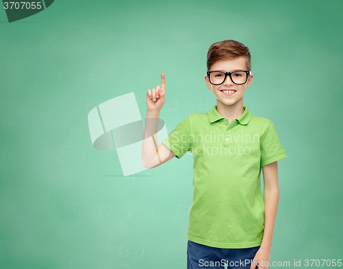Image of happy boy in eyeglasses pointing finger up