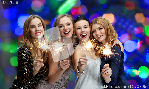 Image of happy young women with sparklers over lights