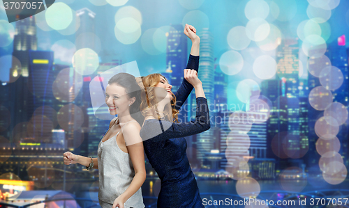 Image of happy young women dancing at night club disco