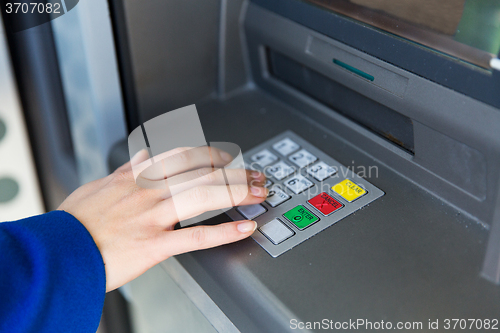 Image of close up of hand entering pin code at cash machine