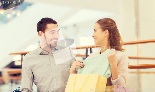 Image of happy young couple with shopping bags in mall