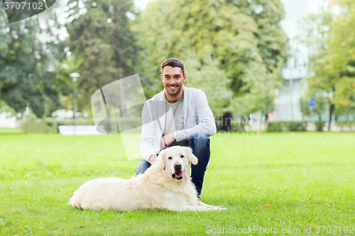 Image of happy man with labrador dog walking in city