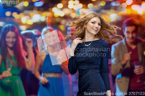 Image of happy young woman dancing at night club disco