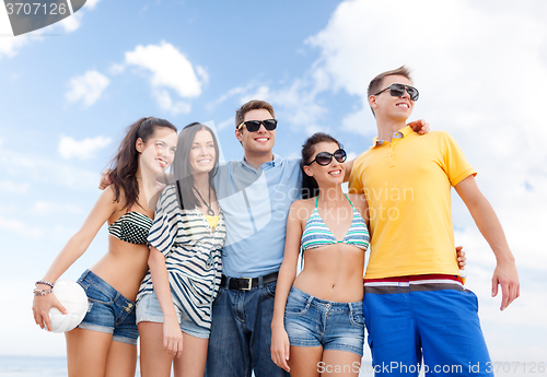 Image of group of happy friends with beach ball