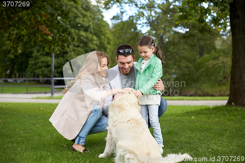 Image of happy family with labrador retriever dog in park