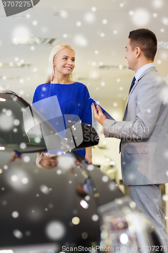 Image of happy woman with car dealer in auto show or salon