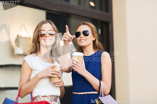 Image of young women with shopping bags and coffee at shop