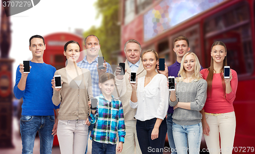 Image of happy people with smartphones over london city