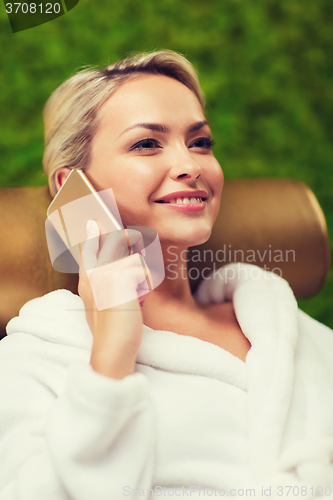 Image of beautiful young woman with smartphone at spa