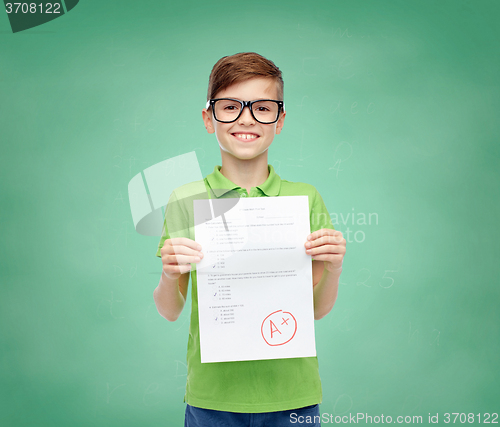 Image of happy boy in eyeglasses holding school test result