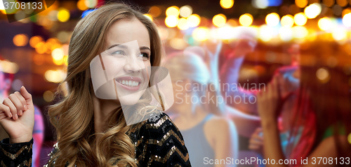 Image of happy young woman dancing at night club disco