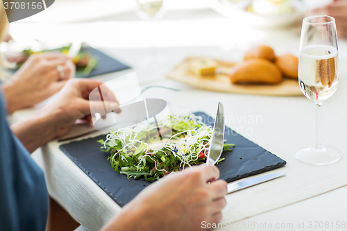 Image of close up of woman eating salad at restaurant