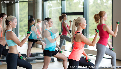 Image of group of women with dumbbells and steppers