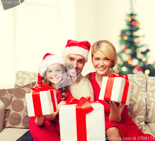 Image of smiling family giving many gift boxes