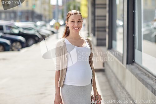 Image of happy smiling pregnant woman at city street