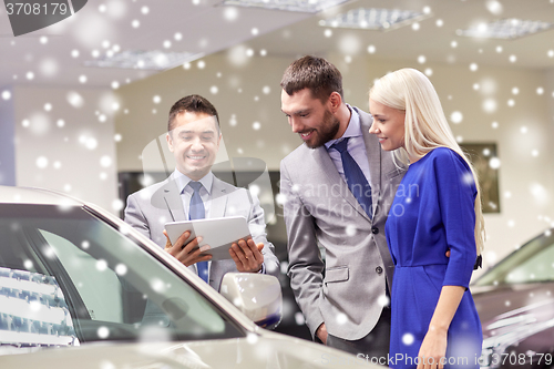 Image of happy couple with car dealer in auto show or salon