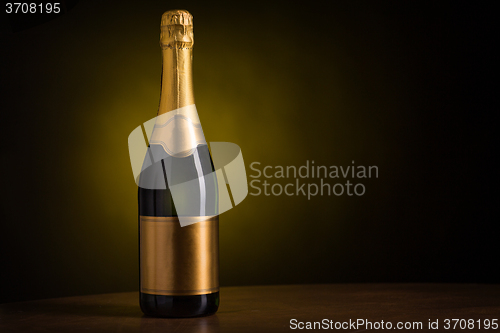 Image of bottle of champagne with blank golden label