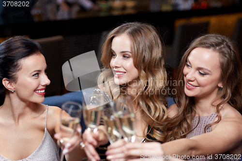 Image of happy women with champagne glasses at night club