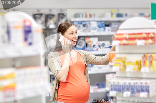 Image of happy pregnant woman with smartphone at pharmacy