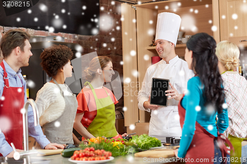 Image of happy friends with chef and tablet pc in kitchen