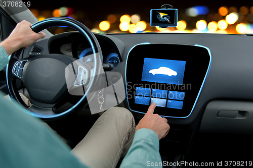 Image of close up of man driving car with on board computer