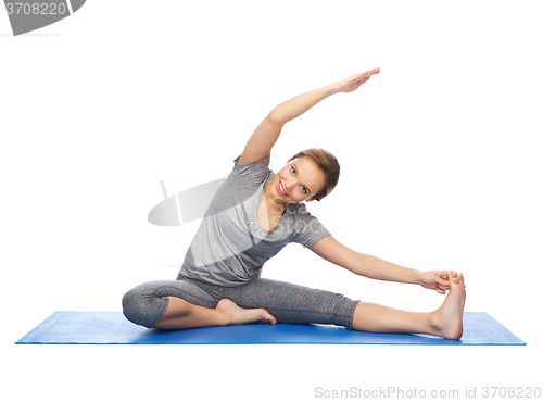 Image of happy woman making yoga and stretching on mat