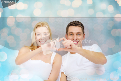 Image of smiling couple showing heart with hands