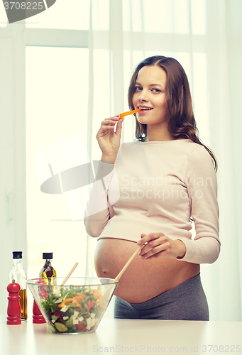 Image of happy pregnant woman preparing food at home