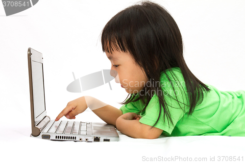 Image of Chinese little girl lying down with laptop