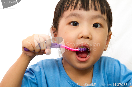 Image of Chinese little girl brushing teeth