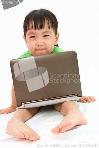 Image of Chinese little girl sitting on floor with laptop