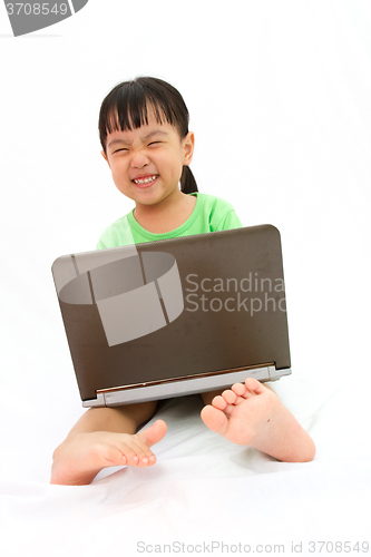 Image of Chinese little girl sitting on floor with laptop