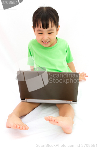 Image of Chinese little girl sitting on floor with laptop