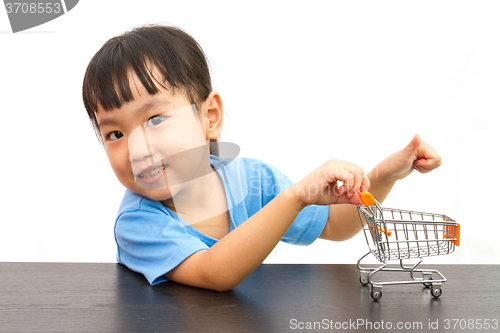 Image of Chinese little girl pushing a toy shopping cart