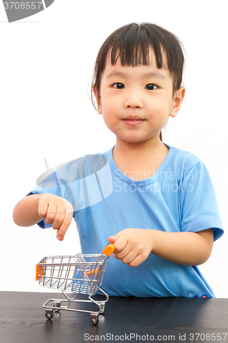 Image of Chinese little girl pushing a toy shopping cart