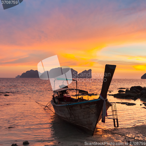 Image of Traditional wooden longtail boat on beach in sunset, Thailand.