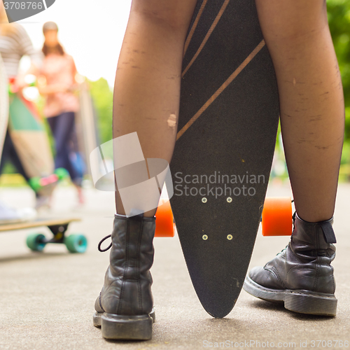 Image of Teenage girl urban long board riding.