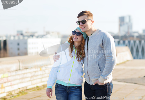 Image of happy teenage couple walking in city