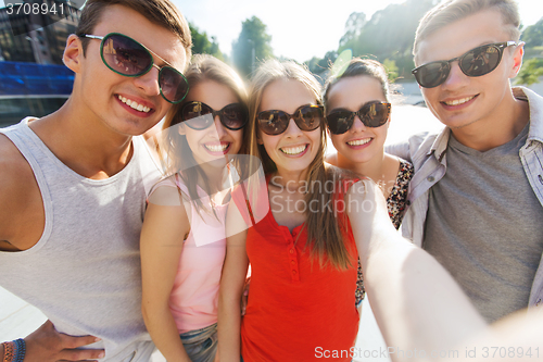 Image of smiling friends taking selfie