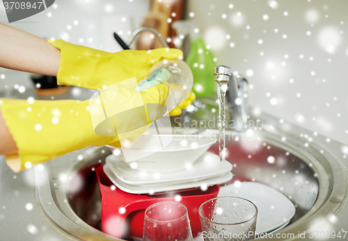 Image of close up of woman hands washing dishes in kitchen