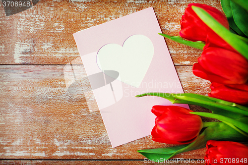 Image of close up of tulips and greeting card with heart