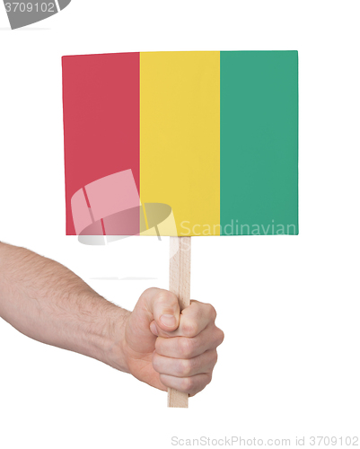 Image of Hand holding small card - Flag of Guinea