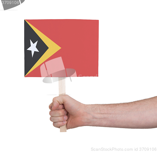 Image of Hand holding small card - Flag of East Timor